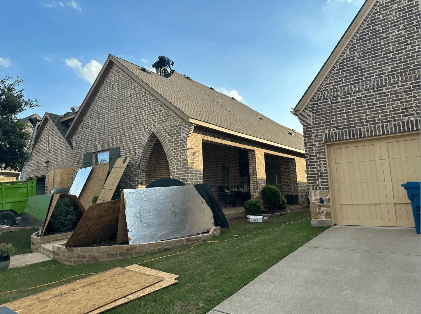 Roof replacement in progress on Honeysuckle Drive in Lantana, TX 76226 — RoofDog crew installing new decking and shingles on a brick home