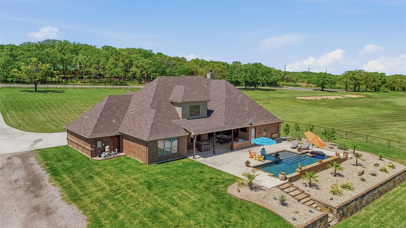 Front elevation of a modern farmhouse with a completed full roof replacement on Westfork Way in Springtown, TX 76082 — RoofDog residential roofing project with architectural shingles
