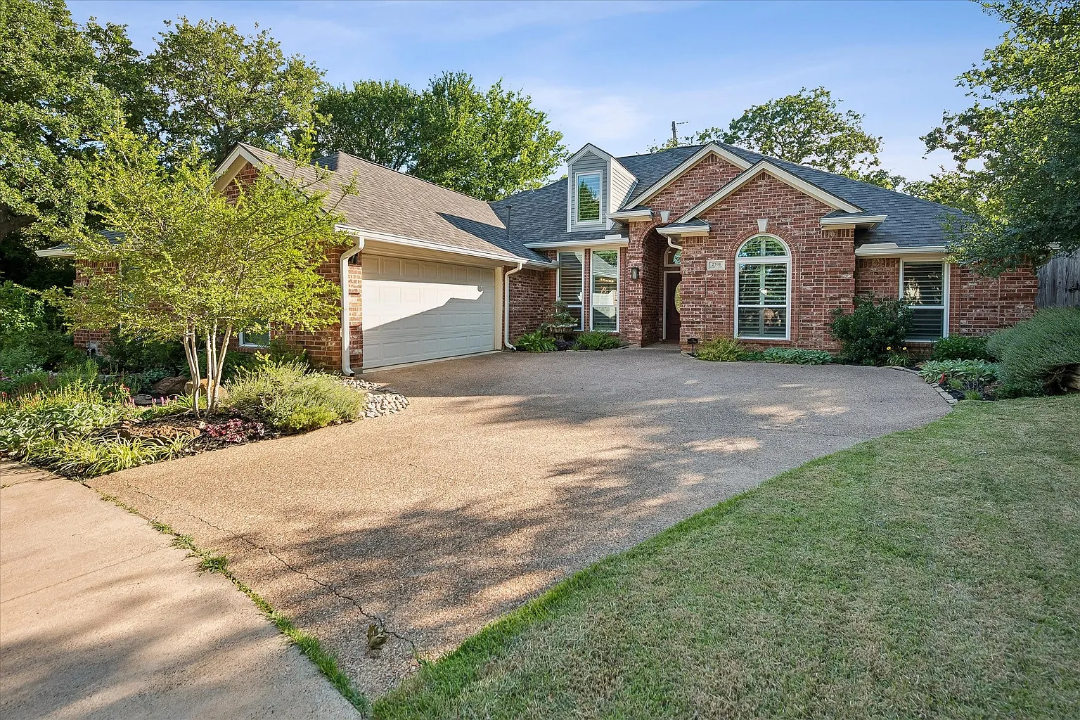 Full roof replacement on Hidden Lake Drive in Grapevine, TX 76051 — traditional brick home with mature landscaping and new architectural shingles by RoofDog
