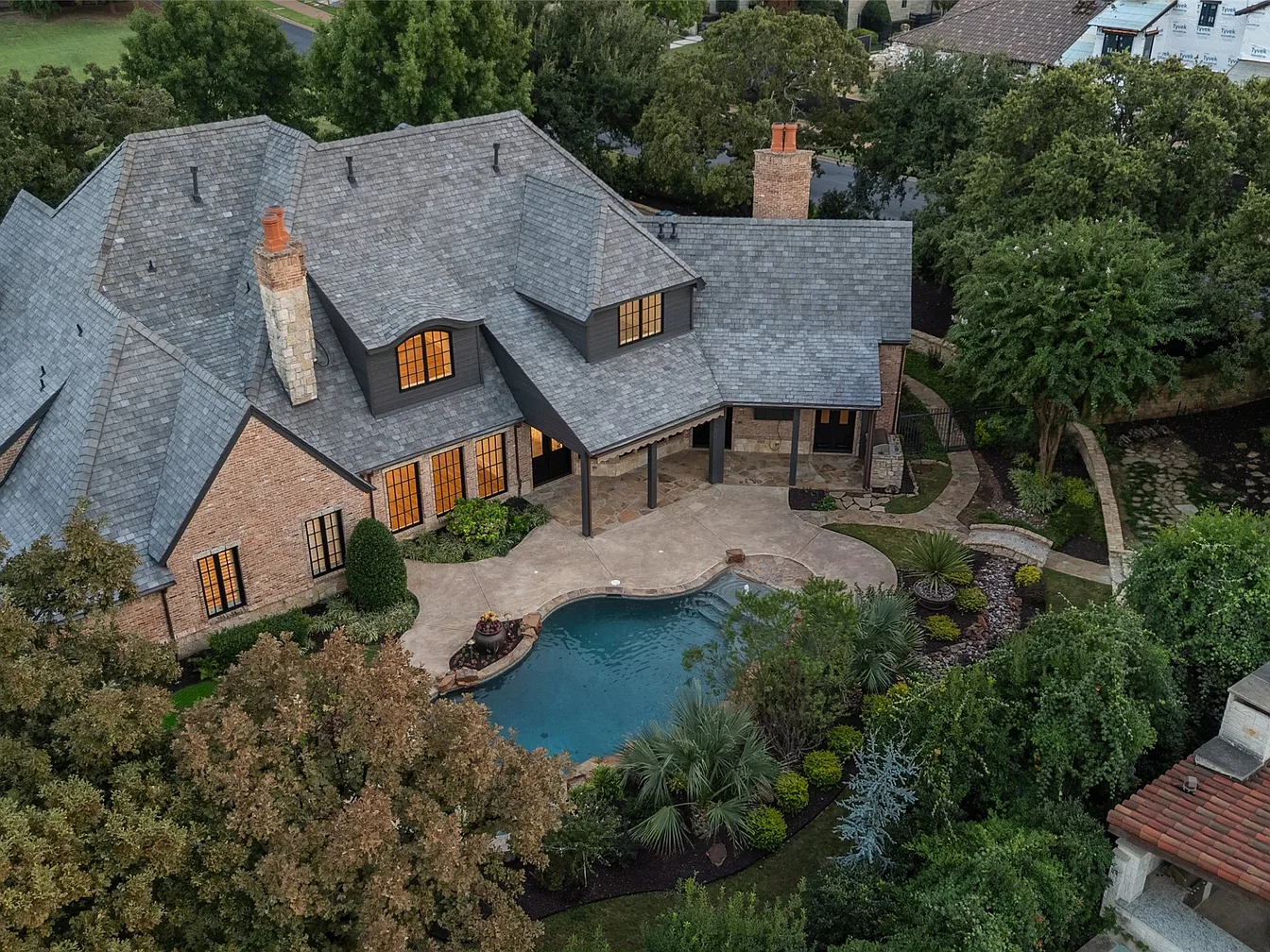 Aerial drone view of a luxury estate in Westlake, TX 76262 with a completed composite slate roof replacement by RoofDog — brick and stone exterior, pool, and mature landscaping
